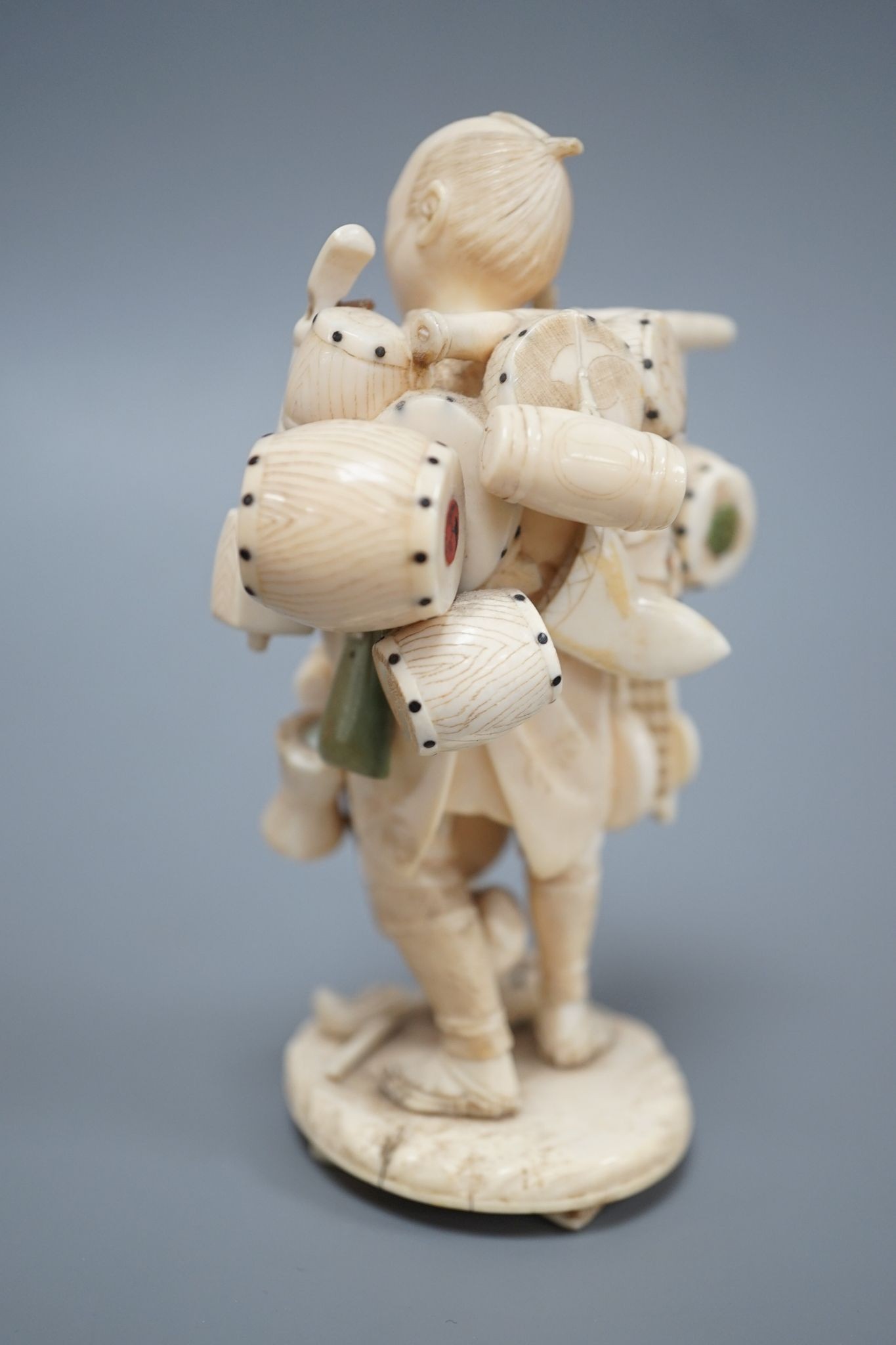 A Japanese ivory okimono of a street vendor, early 20th century 12cm